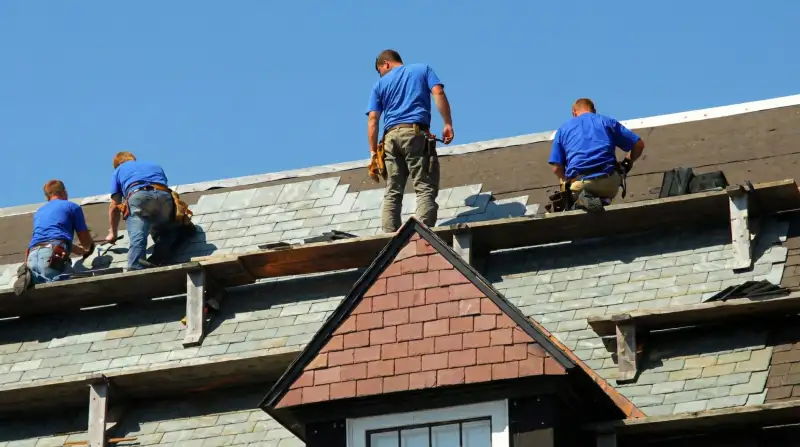 Roof replacement in progress with a team of professional contractors installing new shingles on a residential home in Raleigh, NC